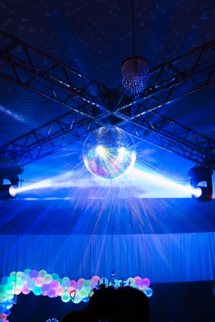 Colorful party setup featuring a disco ball and vibrant lighting in an indoor setting.
