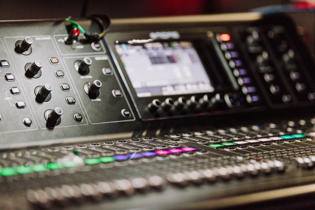 Home Close-up of a professional audio mixer console with digital screen for music production.