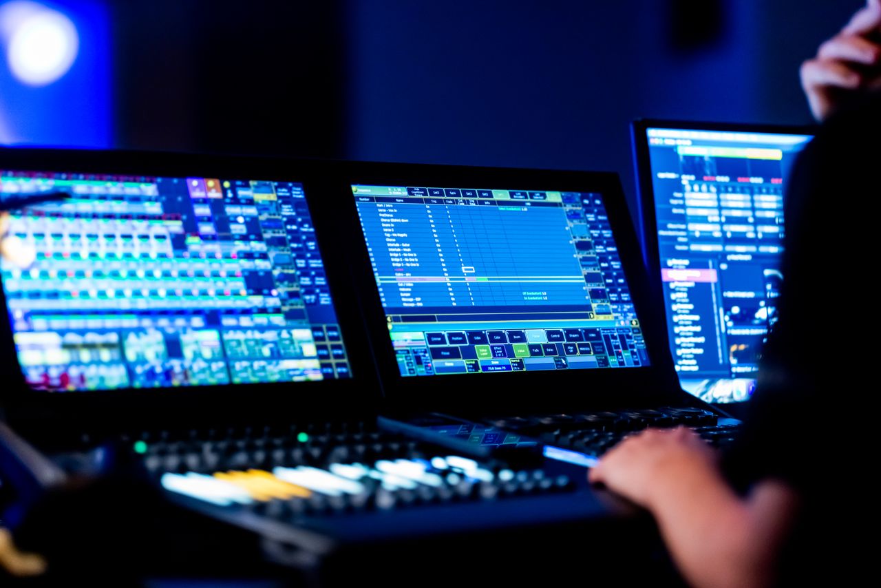 Home Close-up of a sound engineer using a digital mixing console during a live event.